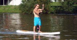 Man Stands at Paddle Board