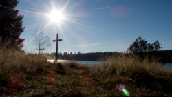 Sun over the lake and a crucifix