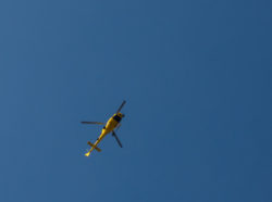 Yellow helicopter against the blue sky