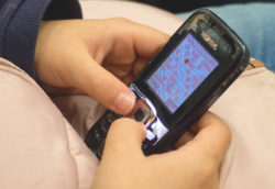 Young Hands Playing Sudoku On Old Mobile Phone