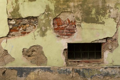 Grungy house facade with cellar window