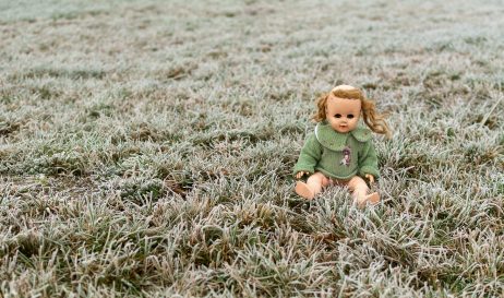 Creepy Doll Sitting in a Meadow